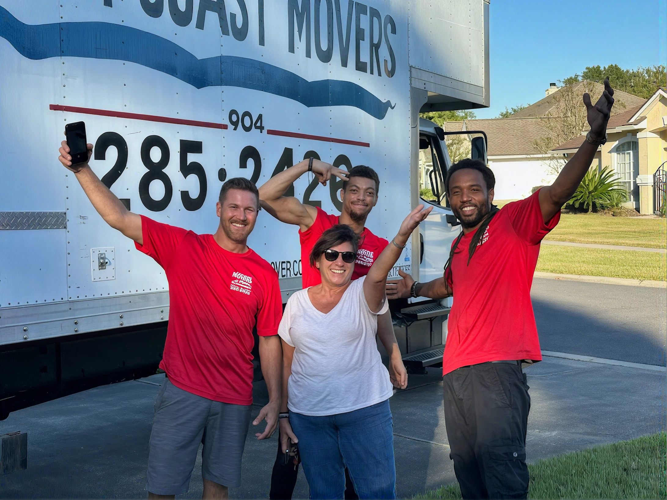 Group celebrating in front of moving truck.