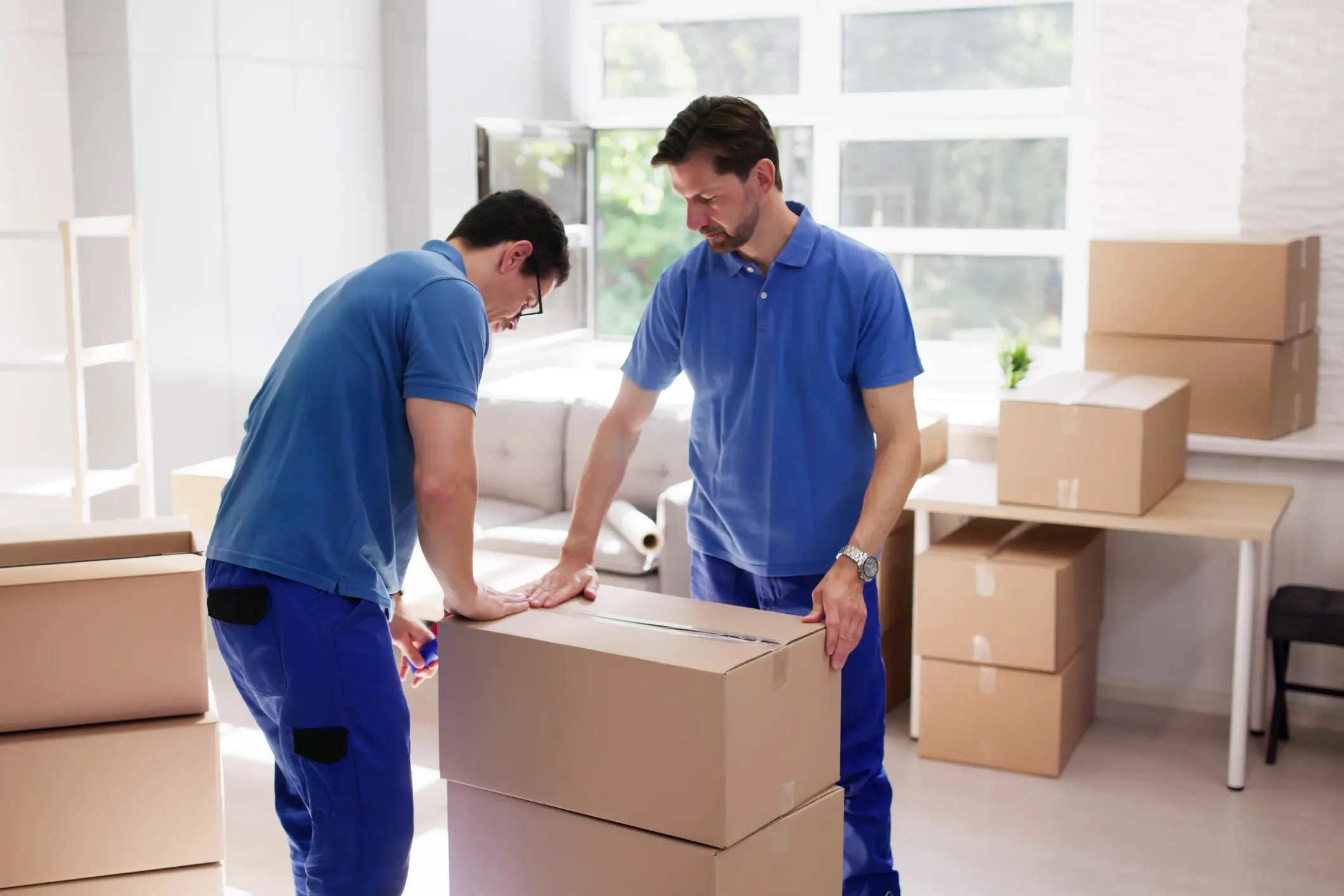 Skilled Mover Wrapping Furniture In Tape For Apartment Delivery Service